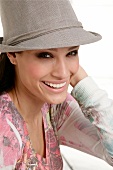 Portrait of beautiful woman wearing hat and multi- colour top, smiling