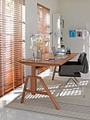 Office with wooden table, chair and wooden blinds on window