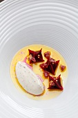 Close-up of celeriac puree, beetroot, potato, mustard seeds and hot butter in bowl