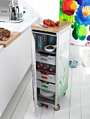 Crockery and bottles in storage cabinet with trolley