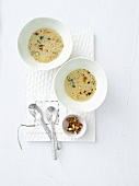 Two bowls of pistachio soup with chestnuts, overhead view