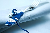 Close-up of forks wrapped with blue ribbon