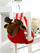 Children's red backpack with moose head on the back of chair