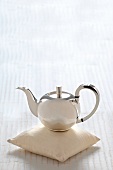 Sterling silver teapot on pillow
