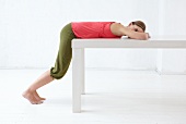 Woman lying on her front on table while exercising