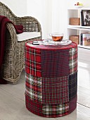A cup of tea on a red-checked patchwork pouffe in a living room