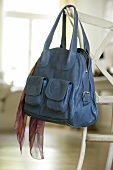 Blue leather bag with scarf, hanging
