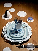 Blue plate with liqueur glasses, ice flowers and sea salt on wooden surface