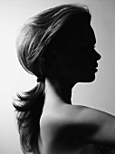 Side view of nude woman with plaited hair, black and white