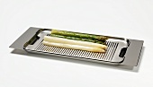Cooked asparagus on a stainless steel serving tray