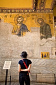 Rear view of woman looking at mosaic of Jesus on wall in Hagia Sophia, Istanbul, Turkey