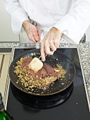 Duck liver being mixed with spatula in pan