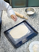 Dough for focaccia bread rolled and spread on baking sheet