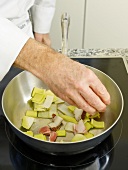 Close-up of man's hands adding ingredients in pan