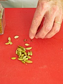 Close-up of man's hand separating cardamom seeds from shell