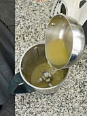 Close-up of liquid being poured in grinder jar
