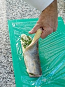 Preparing roulade with artic char on cutting board