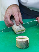 Close-up of artic char being sliced with knife