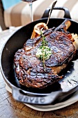 Close-up of grilled steak with herbs in pan