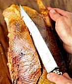 Close-up of roasted duck's breast being sliced