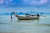 Thailand: einsame Insel, Meer, Fischerboot, Frau im Wasser, Idyll