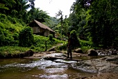 Man standing in river at tropical rainforest village of Huei Kut Chap, Udonthani, Thailand