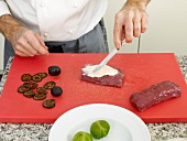 Chef applying a spread on venison steak