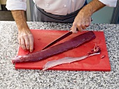 Venison being sliced on cutting board