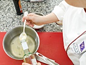 White vinegar being added in pan