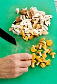 Mushrooms being sliced with knife on board
