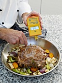 Chef checking temperature of beef steak and vegetables removed from oven
