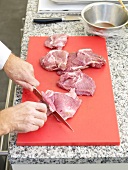 Veal cheeks being sliced with knife