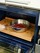 Putting pan with stuffed bell peppers in oven