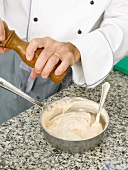 Adding crust white pepper to poultry puree in saucepan