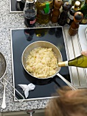Putting white wine in saucepan with sauerkraut