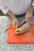 Cutting duck leg on cutting board