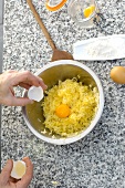 Putting egg yolk to shredded potato