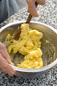 Mixing shredded potato with egg in bowl for potato dumplings