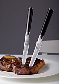 Close-up of steaks with Japanese steak knife on plate