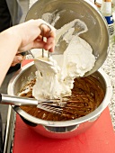 Adding cream to chocolate in bowl