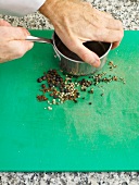 Crushing black peppercorns by sauce pan