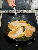 Close-up of pork being fried in frying pan
