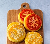 Corn cakes with tomato slices on chopping board