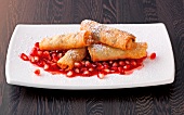 Tofu and soy spring rolls with pomegranate in serving dish