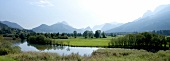 View of landscape with pasture, river and mountains in Styria, Austria