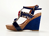 Close-up of sandal with royal blue cork wedges decorated with precious stones