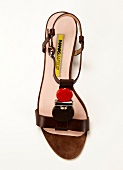 Close-up of strap sandals with precious stone on white background