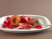 Peach with raspberry sauce in serving dish