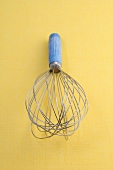 Whisk on yellow background