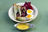 Artichoke with red cabbage and eggs on plate with mayonnaise